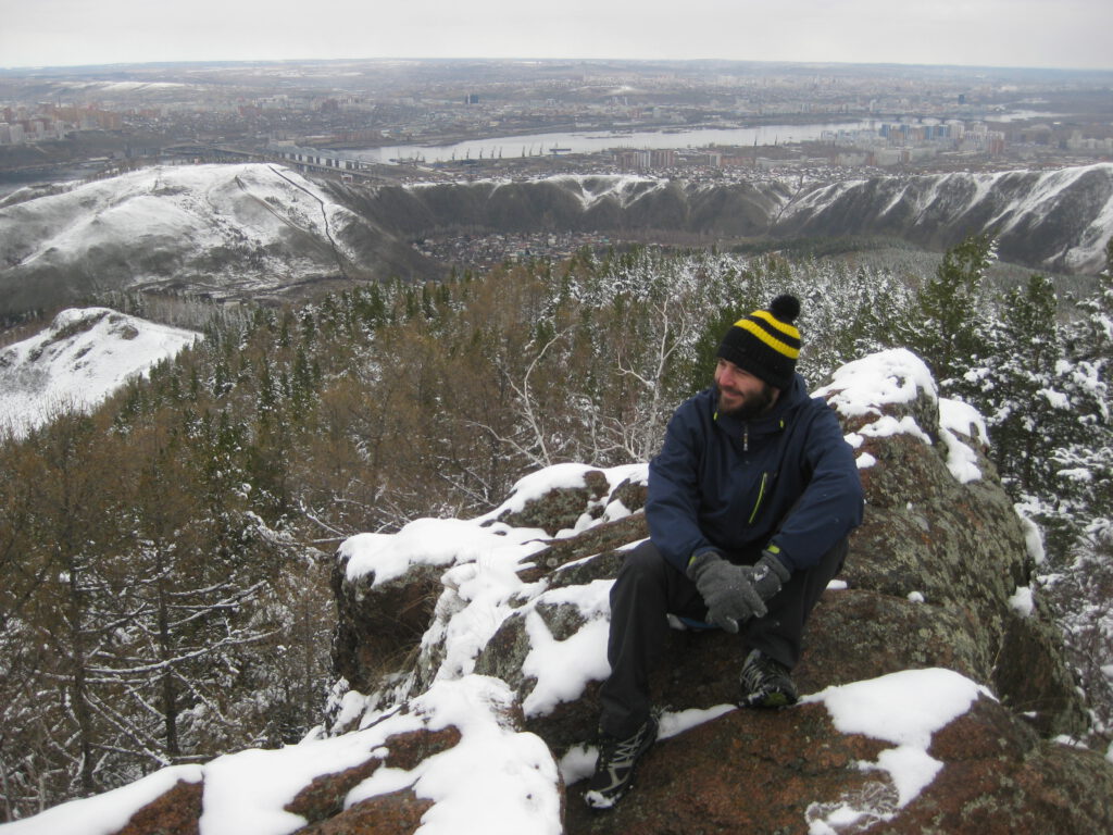 Ich sitze auf einem Fels im Stolby Park. Blick über Krasnojarsk und den Jenissei. 