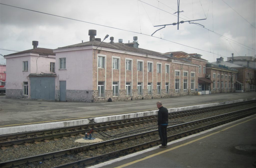 Kleiner Bahnhof an der Strecke der Transsibirischen Eisenbahn zwischen Nischni und Jekaterinburg. Ein Mann steht am Bahnsteig, 