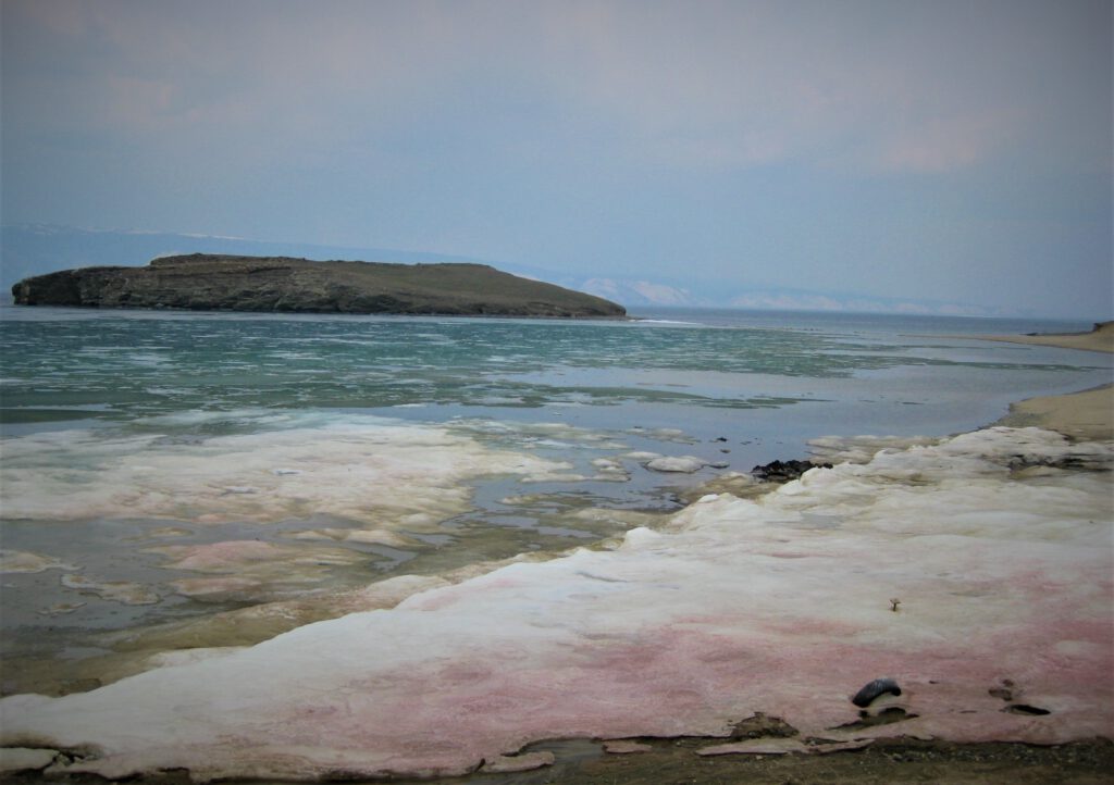 Rot gefärbtes Eis am Ufer des auftauenden Baikalsees bei Olchon. 