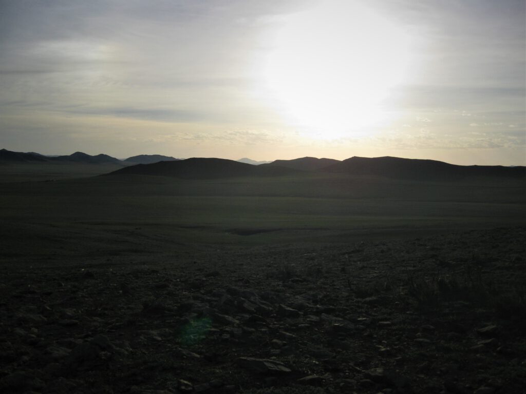 Sonnenuntergang hinter Hügeln in der mongolischen Steppe. 