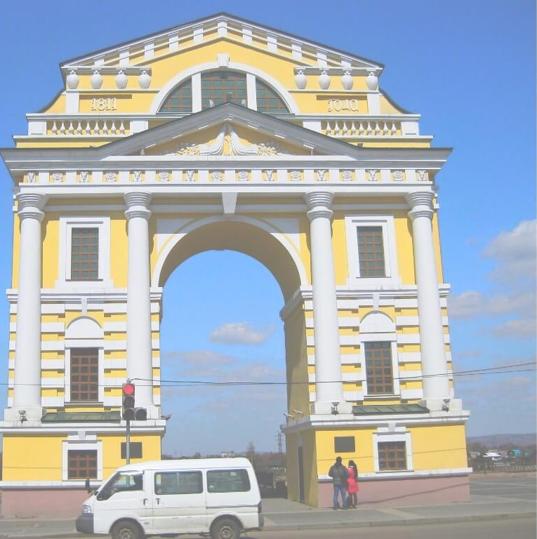 Das gelb-weiße Moskauer Tor in Irkutsk vor blauem Himmel.