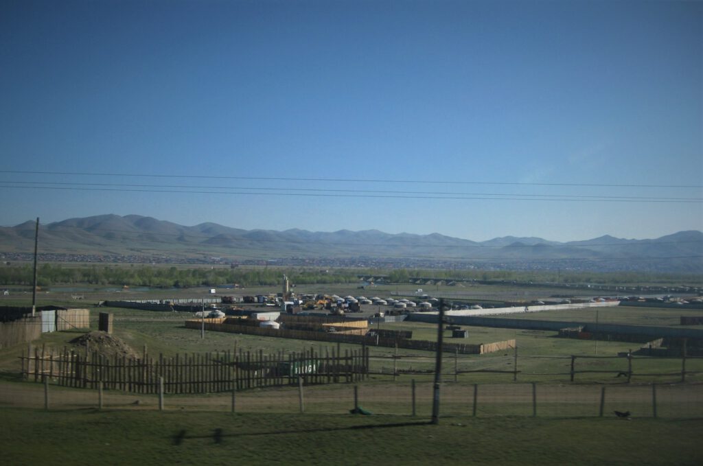 Zug Mongolei. Blick aus dem Fenster am Stadtrand von Ulan Bator. Eine Siedlung von Gers (Jurten) ist zu sehen. 