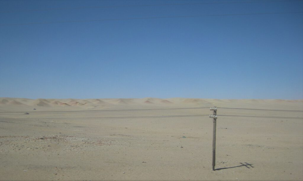 Ein hölzerner Strommast in der Wüste Gobi. 