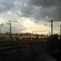 Sonnenuntergang hinter den Wolken über den Schienen nahe des Bahnhofs in Brest. Grenze Polen Weißrussland. East Rail Stories