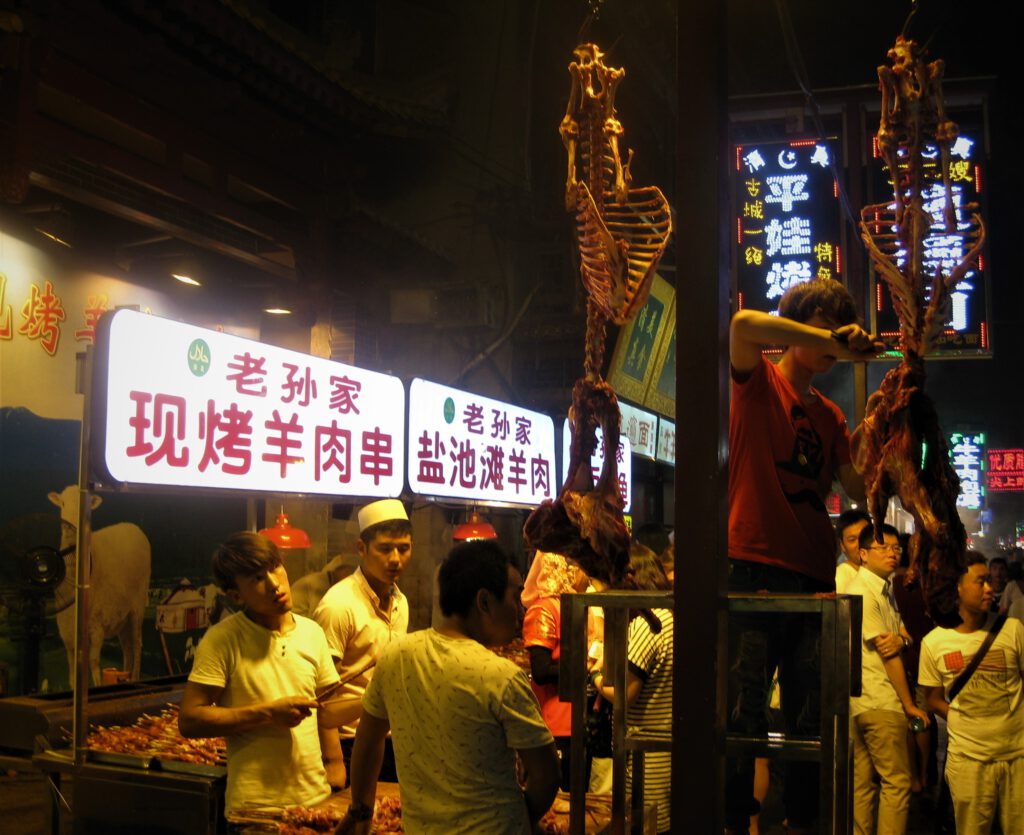 Lamm-Skelette hängen über der Beiyuanmen Straße. Hier werden Spieße zubereitet.