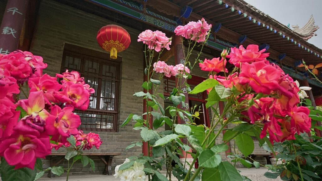 Floraler Schm uck vor einer Halle des Jianfu-Tempels.