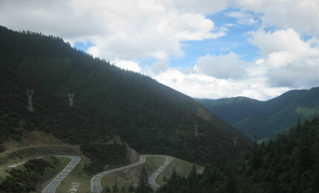 Neu gebaute Serpentinen schlängeln sich durch die grünen Berge von Sichuan. 