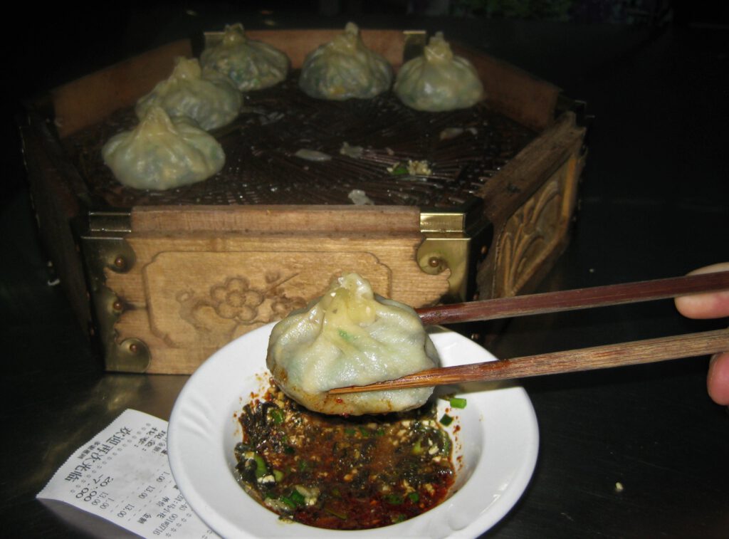 Vegetarische Baozi werden auf hölzernem Dampfgareinsatz serviert.