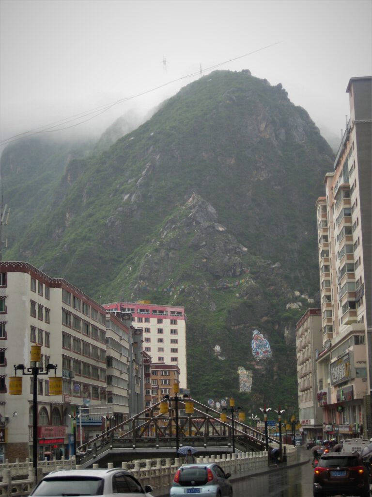 Ein Berg erhebt sich vor einer Hauptstraße von Kangding. 