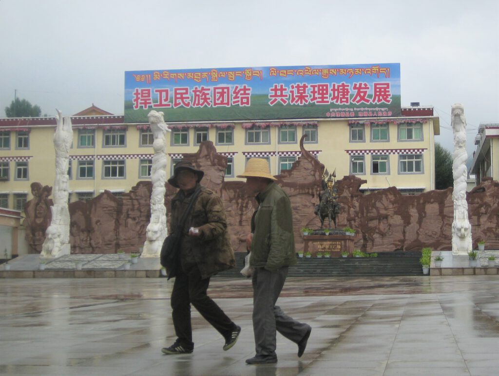 Zwei Männer mit Hüten auf den King Gesar  Square von Litang. 