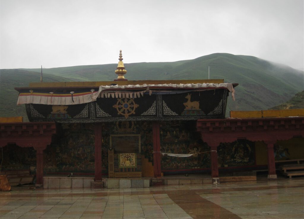 Altar mit Mandala vor den grünen Hügeln von Litang.