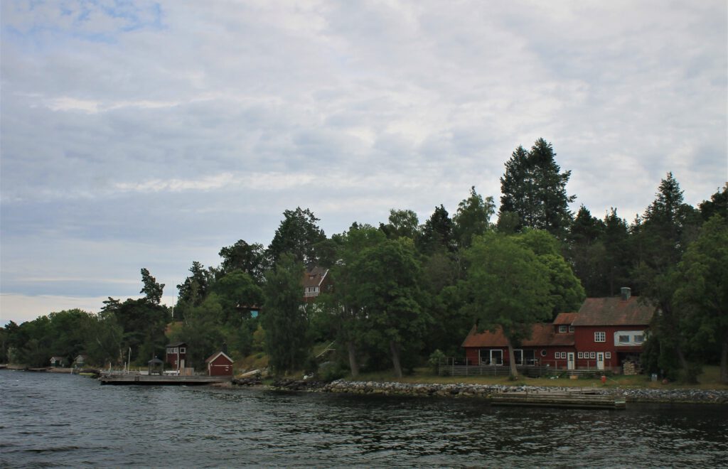 Eine Insel im Stockholmer Schärengarten mit roten Holzhäusern. 