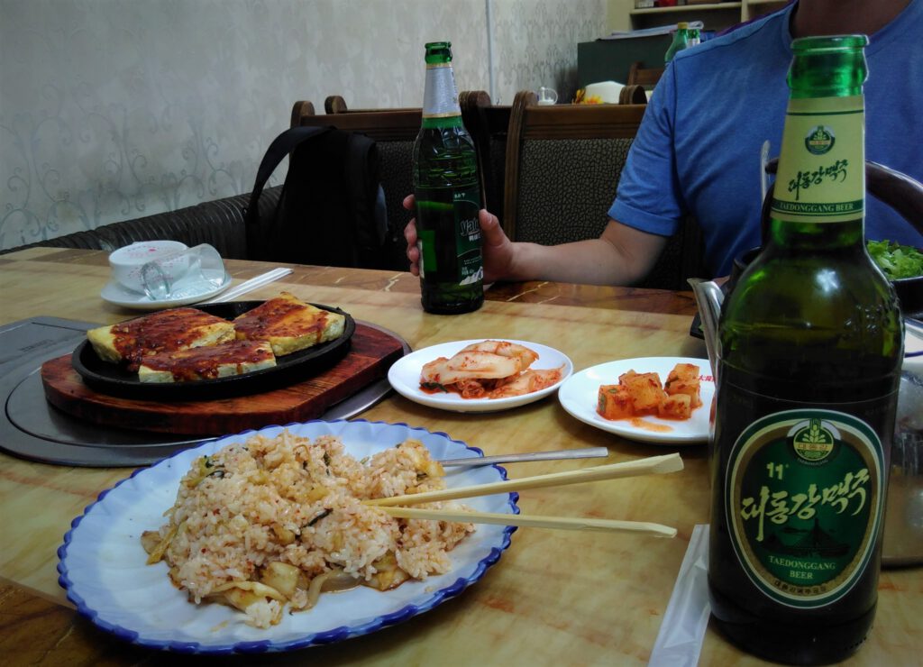 Reis- und Tofugerichte in einem koreanischen Restaurant in Dandong. Dazu ein nordkoreanisches Bier. 