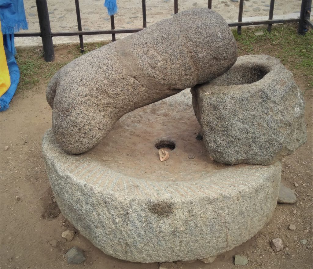 Stein-Phallus, der schräg aufrecht einem Steingefäß aufliegt. 