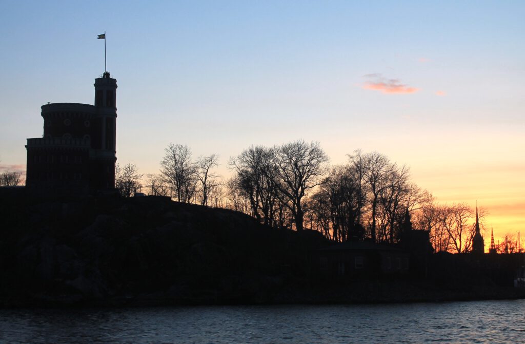Bei Sonnenuntergang wird die schwedische Fahne auf dem Turm des Kastells von Kastellholmen von Soldaten eingeholt.