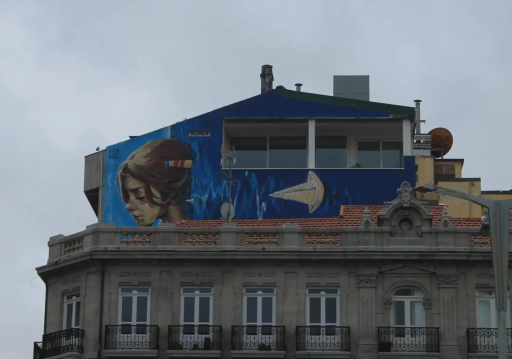 Blaues Seefahrer-Graffiti mit Frauenkopf auf einer Haussfassade.