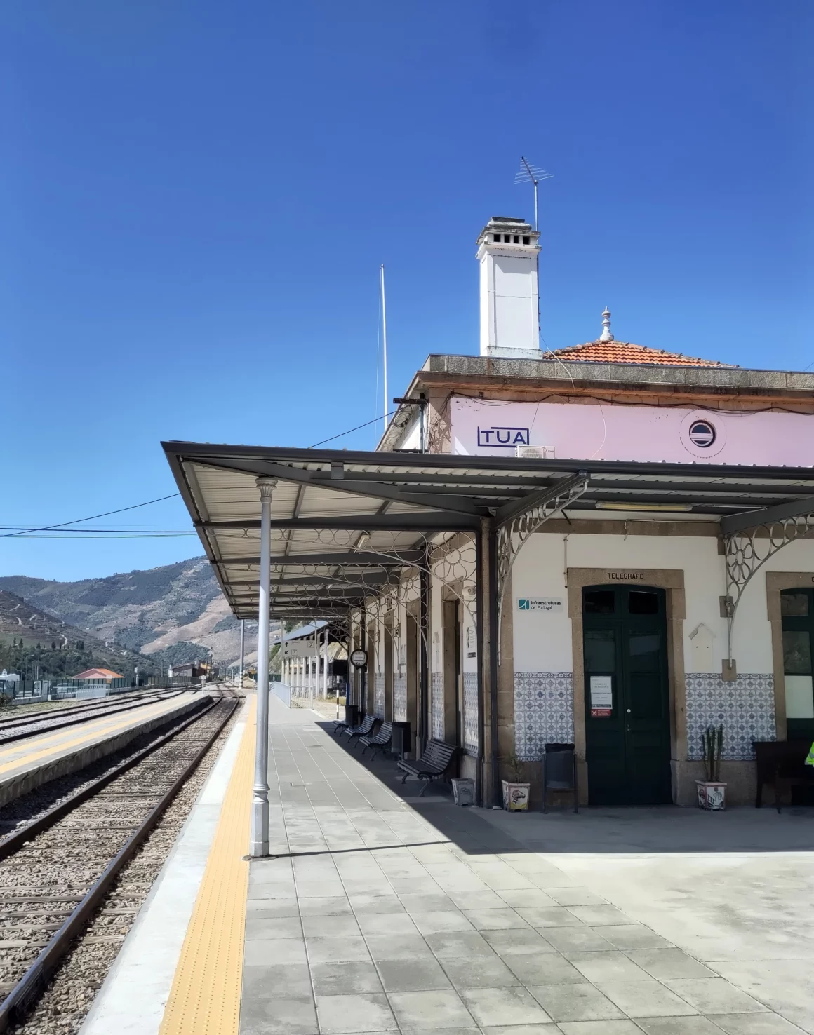 Blick auf leeren Bahnsteig und Bahnhofsgebäude in Tua