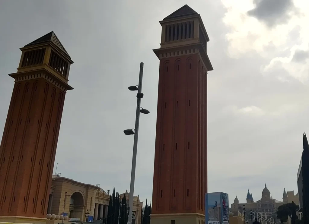 Plaça d'Espanya - Die beiden dem Glockenturm von St. Markus gestalteten Türme von unten in den Himmel ragend. Im Hintergrund der Nationalpalast.