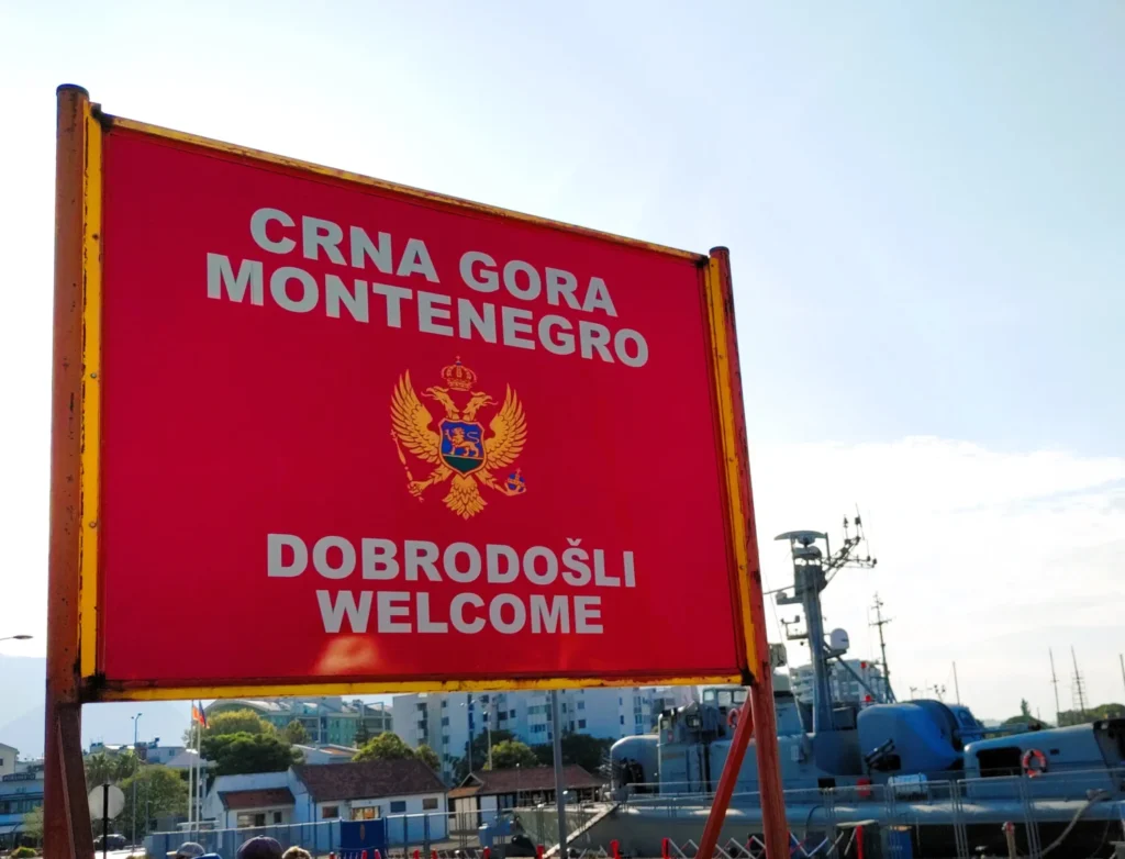 Ankunft am Hafen von Bar Montenegro: Rotes Schild mit Nationalflagge und AUfschrift "Crna Gora Montenegro Dobrodosli Welcome".