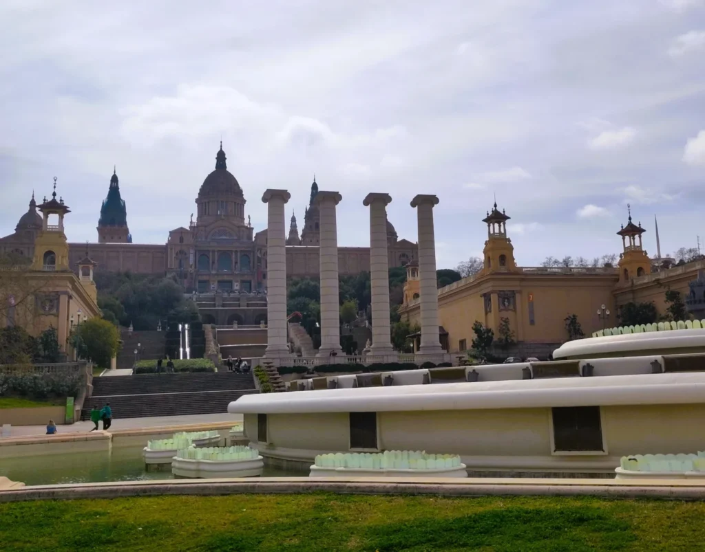 Vier Säulen vor dem Nationalpalast in Barcelona. Davor der inaktive magische Brunnen.