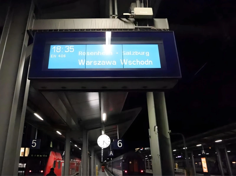 Anzeigetafel in München Hauptbahnhof, Gleis 6. Abfahrt EN 406 nach Warschau Wschodnia, über Rosenheim und Salzburg, um 18:35.
