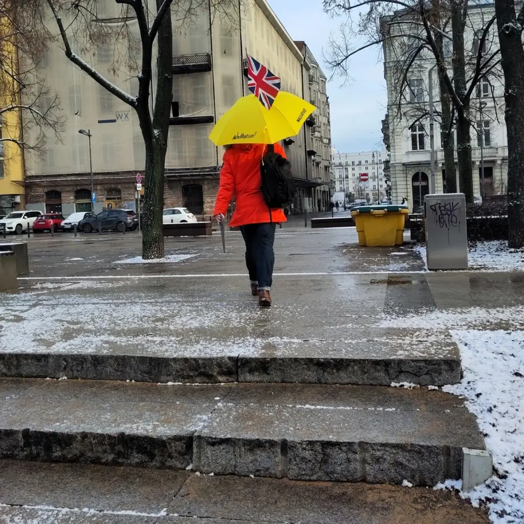 Tourguide mit gelbem Regenschirm vor der Prozna Straße am Rande des Warschauer Ghetto
