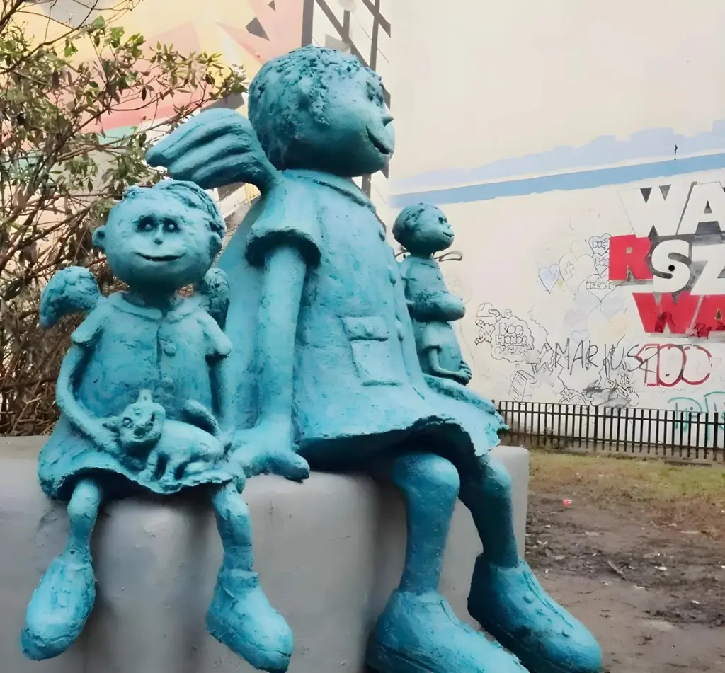 Familie von blauen Engeln vor dem Mural Praski "Desperados" in der Ulica Zabowska.