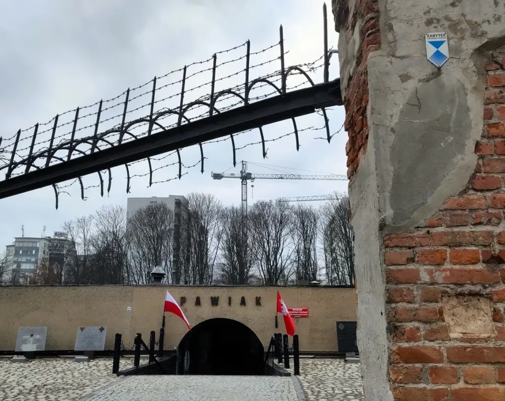 Eingang zum Pawiak Gefängnismuseum. Stacheldraht und alte Backsteinmauer von erhaltenen Resten des Tores.