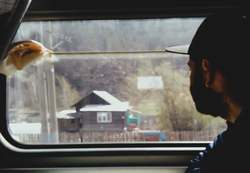 Transsibirien Eisenbahn – Meditativer Blick aus Zugfenster. Sibirische Holzhäuser