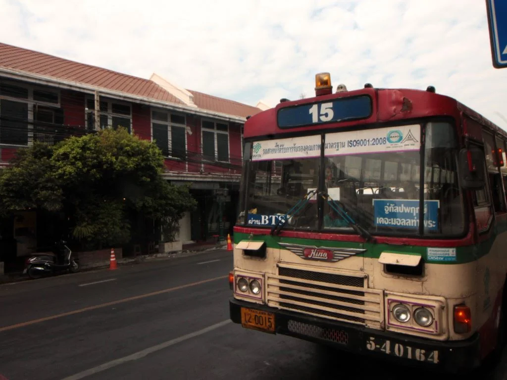 Alter Bus in Bangkok mit der Nummer 15. Fahrtziel in Thai angegeben. 