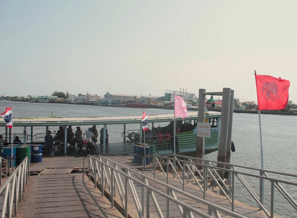 Fähre am Pier in Maha Chai. Fußgänger und Motorradfahrer sind an Bord. 