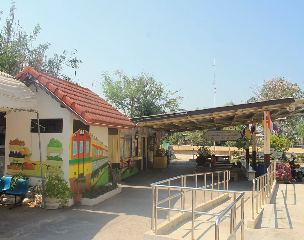 Bahnhof Ban Laem in Tha Chalom. Am Hauptgebäude ein buntes Gemälde des Zugs nach Mae Klong. 