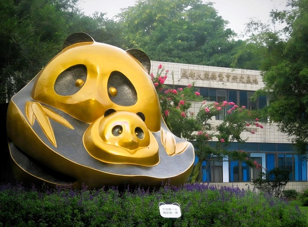 Panda Base. Goldene Panda-Skulptur mit Panda-Mutter und Panda-Baby 