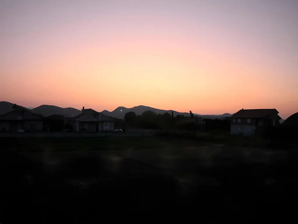 Organe, Pink und Violett gefärbter Himmel nach den Sonnenuntergang in Montenegro, kurz vor Podgorica.