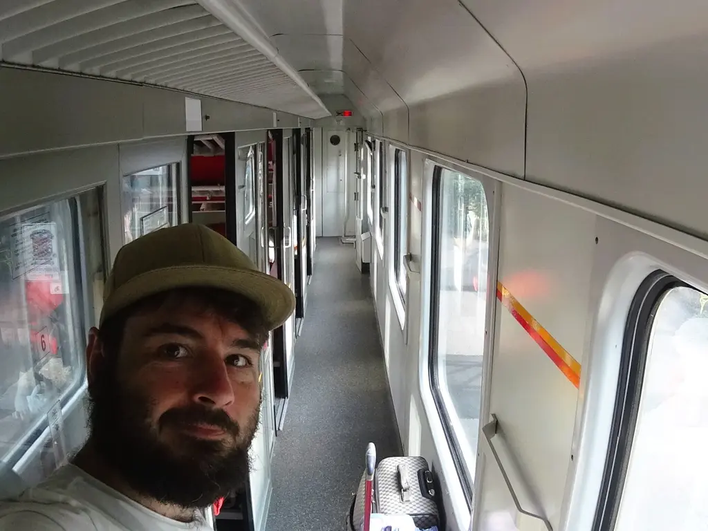 Ich im Gang des Abteilwagens des Tageszugs Tara auf dem Weg nach Montenegro 2019. Saubere, helle Innenverkleidung.