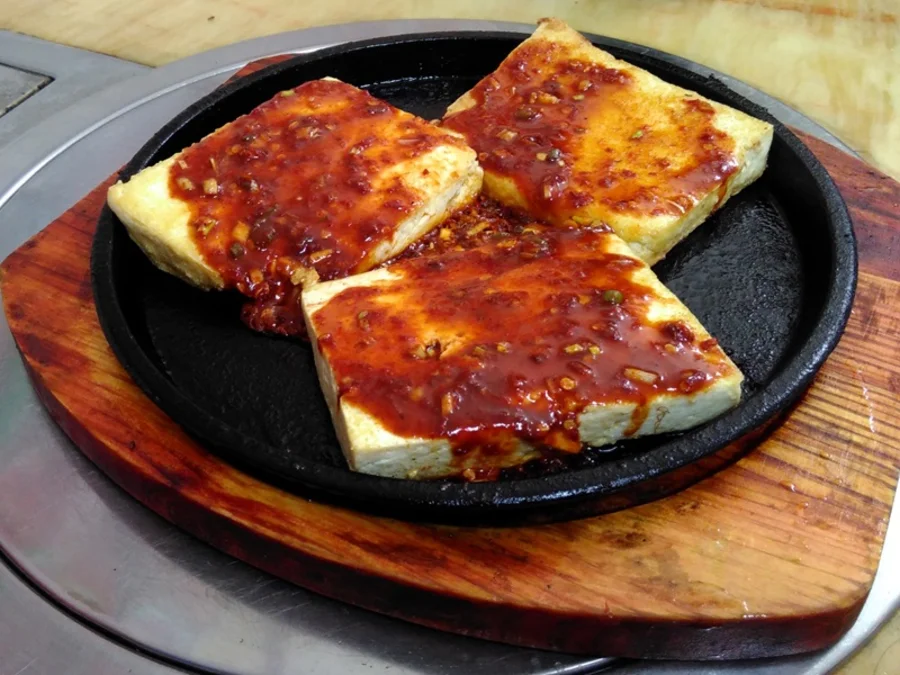 Frittierter Tofu in Eisenpfanne. Mit rotem Chili-Topping. 