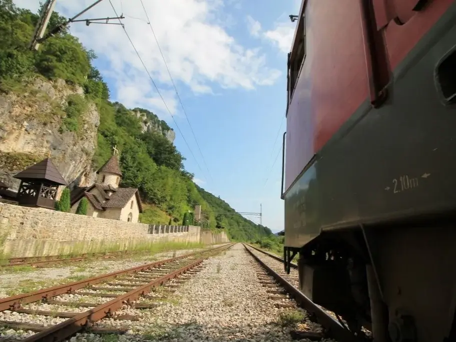 Foto neben der Lok auf Gleishöhe. Zwei Schienenspuren entlang des Klosters Kumanica in Serbien.