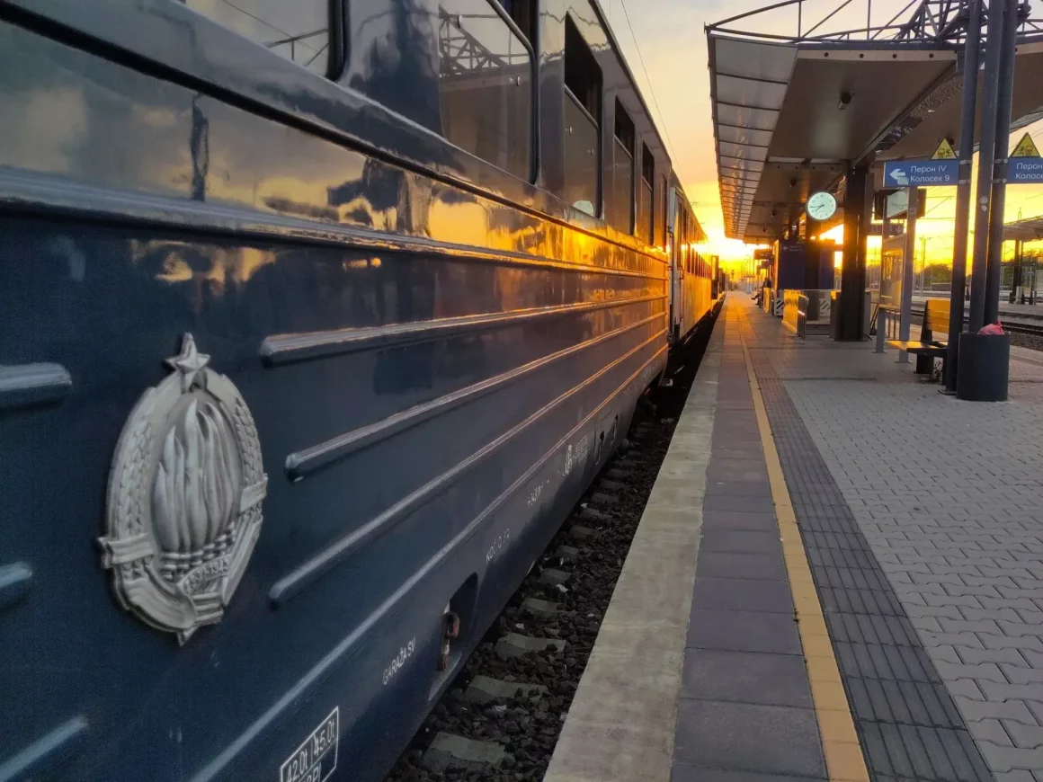 Ein alter Schlafwagen von Titos Blauem Zug von der Seite gegen die untergehende Sonne am Bahnsteig in Zemun. Mit Flammen-Wappen der jugoslawischen Staatsbahn auf Plakette.