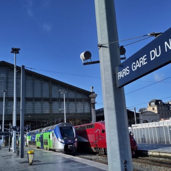 Bahnhofsschild mit der Aufschrift "Paris Gare du Nord" am Bahnsteig hinter der Empfangshalle.