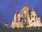 Die Basilika Sacre Coer auf dem Montmarte bei Nacht. Menschenmassen auf der Treppe.