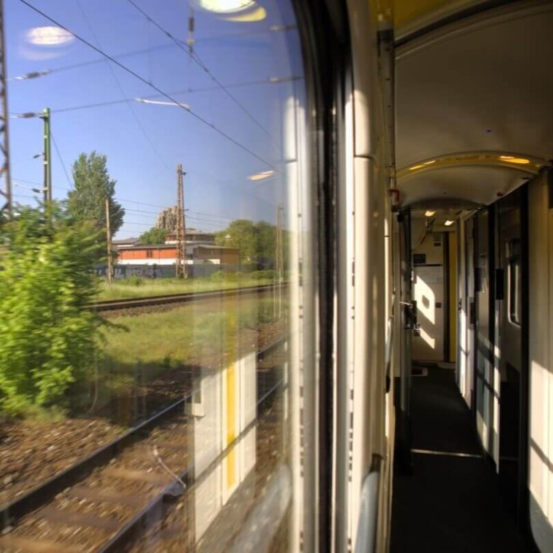 Gang im Abteilwagen des Nachtzugs. Links Blick aus dem Zugfenster am Morgen.