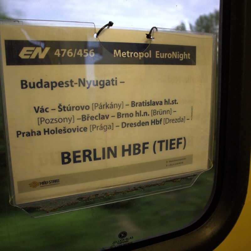 Route auf Schild im Fenster der Zugtür. Budapest-Nyugati-Vac-Sturovo-Bratislava-Breclav-Bro-Praha Holesovice-Dresden-Berlin Hbf