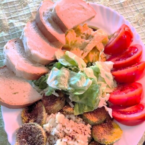 Teller mit Brot, Tomaten und anderem Gemüse.