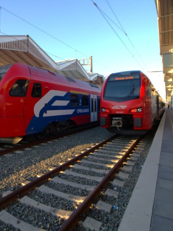 Zwei rote SOKO Schnellzüge in benachbarten Gleisen am Bahnsteig in Novi Sad. Balkan Express