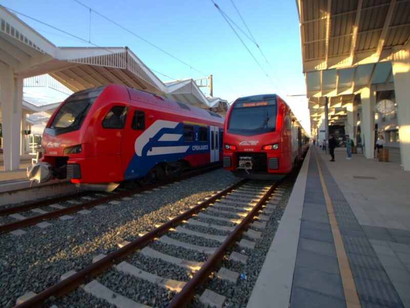 Zwei rote SOKO Schnellzüge in benachbarten Gleisen am Bahnsteig in Novi Sad. Balkan Express